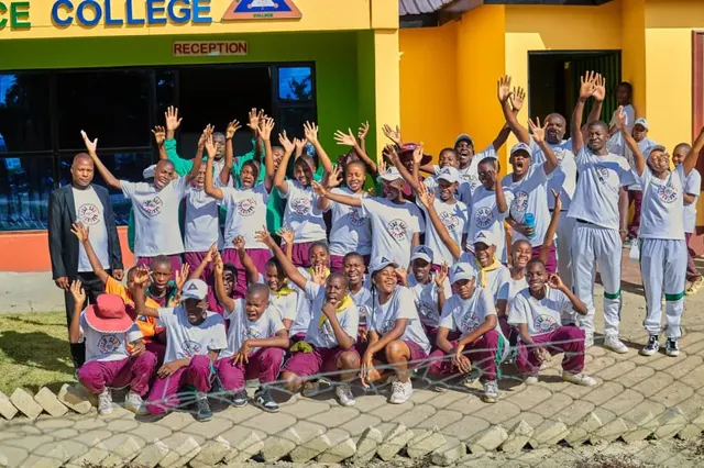 Learners and adults celebrating outside the college