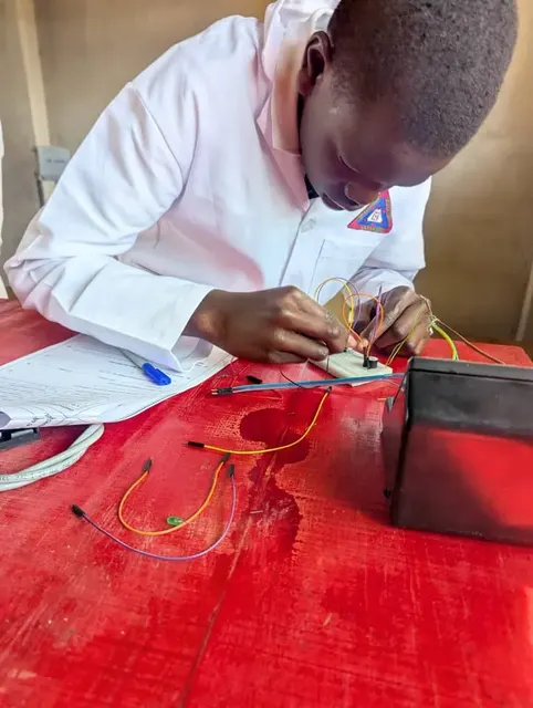 A learner working with an electronics circuit