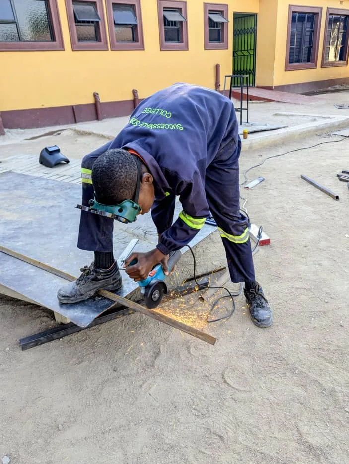 A learner using protective equipment during a metalwork activity